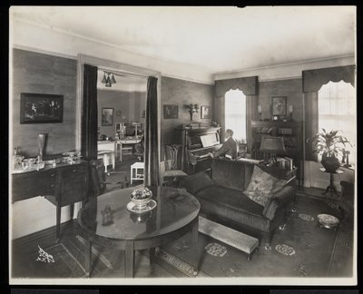 A Man Playing the Piano in a Living Room of the A.C. Cronin Residence by Byron Company